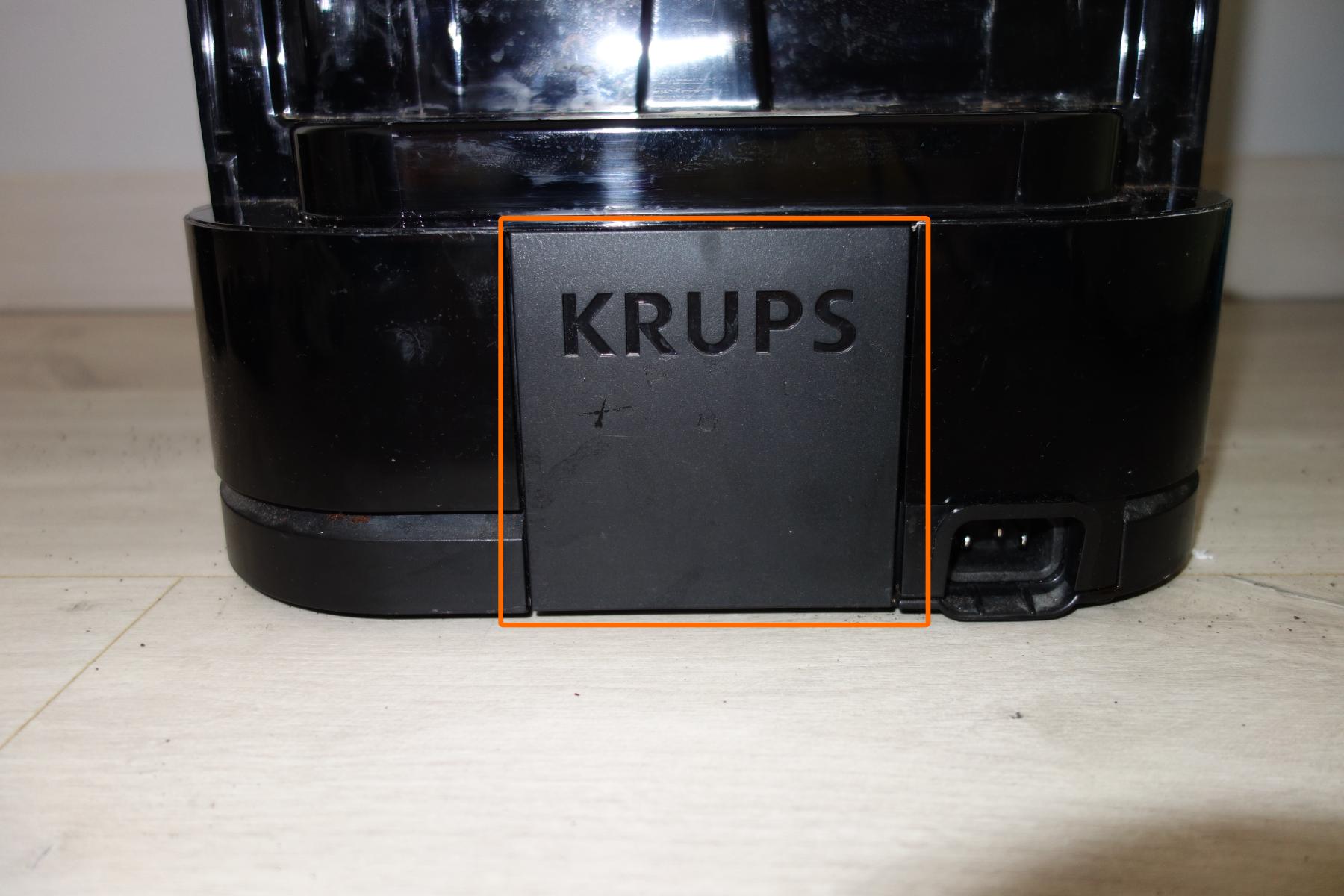 Étape 3e : Déclipser le cache noir marqué Krups à l'arrière